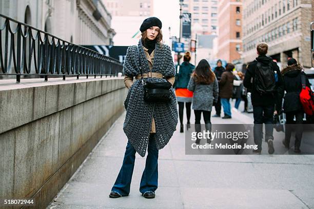 Russian model Irina Liss wears a BCBG jacket belted trench coat, an oversized knit Scoop scarf belted with her coat, a 3.1 Phillip Lim black fringe...