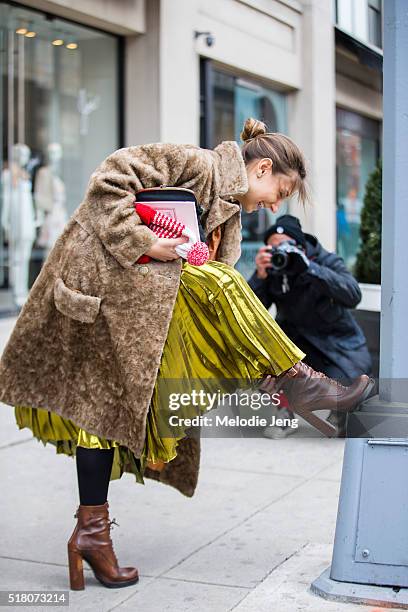 Jenny Walton is photographed while wearing a vintage fur coat, Gucci Prefall 2016 metallic gold skirt, and brown leather Prada boots during New York...