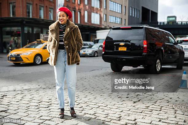 Photographer Tamu McPherson wears a red beret, fur coat, high-waisted vintage-style jeans, and Gucci shoes during New York Fashion Week: Women's...