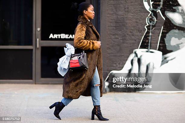 Rajni Jacques wears a needle and thraed choker, ASOS fur coat, Dior purse, and Madewell jeans before the Zimmermann show in Chelsea during New York...