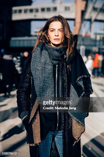 Russian model Dasha Denisenko exits the Tibi show at Skylight 60 Tenth in a black jacket with an oversized knit collar and a wool and cashmere scarf...