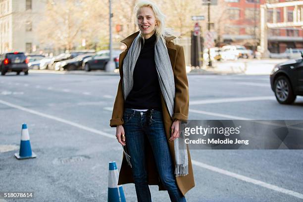 French model/actress Aymeline Valade attends the Lacoste show in a camel coat, gray scarf, Lacoste navy sweater, and jeans at Spring Studios during...
