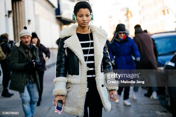 Dominican model Lineisy Montero exits the Lacoste show at Spring Studios in long Coach bomber jacket with shearling and leather and green Beats...