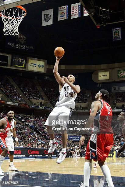 Richard Jefferson of the New Jersey Nets attempts a layup against Eddie House of the Charlotte Bobcats on November 30, 2004 at the Continental...