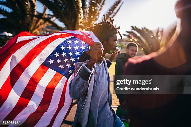 multi-ethnischen eine gruppe von skater zu fuß am strand entlang straße - american flag beach stock-fotos und bilder