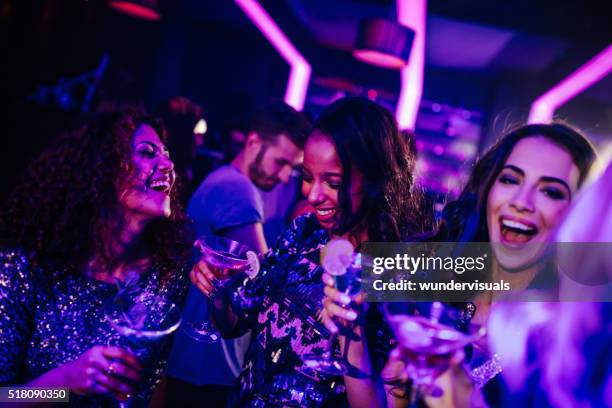 felice giovane donna godendo di un cocktail in festa la notte club - club girl foto e immagini stock