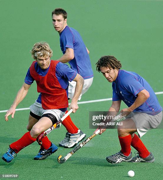 New Zealand field hockey player Simon Towns is tackled by teammate David Kosoof during a practice session at the National Hockey Stadium in Lahore,...