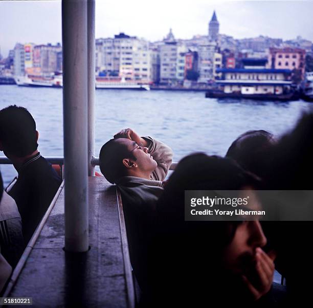 Man sleeps on a ferry boat going from Uskudar station on the Asian side of Istanbul to Eminonu station on the European side of the city, early in the...