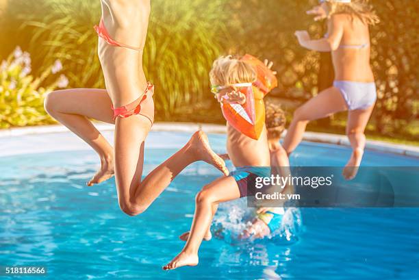 four children jumping into a pool - kid jumping into swimming pool stock pictures, royalty-free photos & images