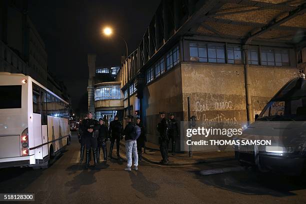 Police officers and gendarmes stand guard as they evacuate migrants and refugees from a makeshift camp under the Stalingrad railway station in Paris...