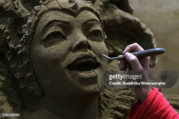 Sand sculptor finishes on sand sculpture face named Carnival in Rio de Janeiro, ahead of the eight annual exhibition 'World Travel By Sand - South...