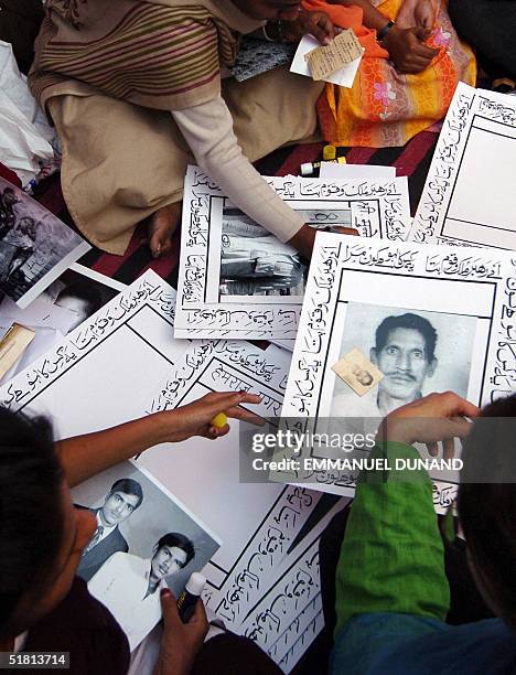 Indian activists sort through picture portraits of deseased victims of the 1984 gas leak disaster, to be used during an overnight candle light vigile...