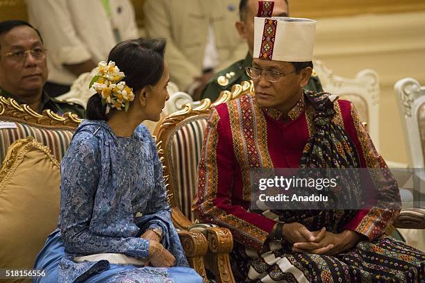 Myanmar's new Foreign minister Aung San Suu Kyi chats with Vice president Henry Van Thio as they attend the ceremony to handover the country's...