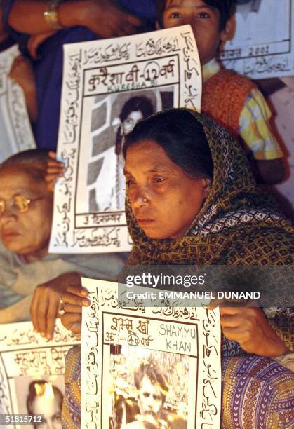 Bhopal gas leak victims, displaying portraits of lost loved ones, hold a candle light vigile to the victims to mark the 20th anniversary of the...