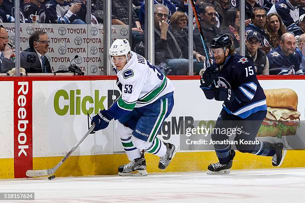 Bo Horvat of the Vancouver Canucks plays the puck down the ice as Matt Halischuk of the Winnipeg Jets gives chase during first period action at the...