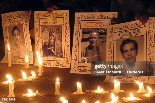 Portraits of deseased Bhopal gas leak victim are held by relatives taking part in a candle light vigile marking the 20th anniversary of the...