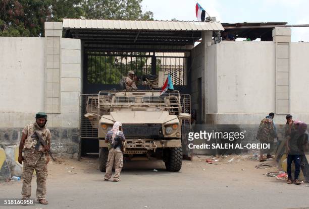Loyalist forces stand guard outside the central prison in the Mansoura residential district of Yemen's second city of Aden after they re-took it and...