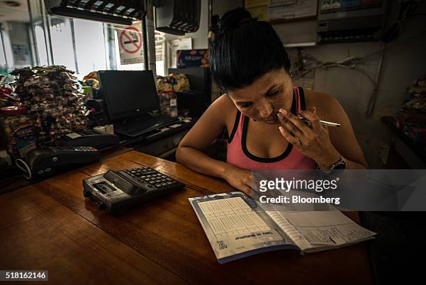 Without electricity to power a computer, Yessika Carrera keeps a handwritten inventory of all the items she sells at a state-run gas station and...