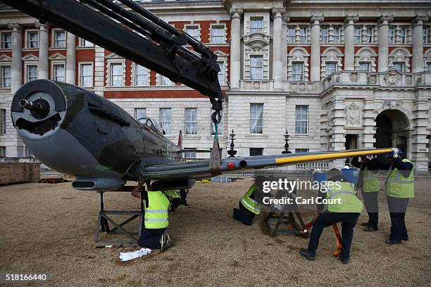 The wing of a World War 2 Spitfire Mk XVI is fitted onto the body of the plane as it assembled at Horse Guards Parade on March 30, 2016 in London,...