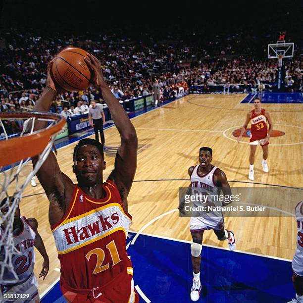 Dominique Wilkins of the Atlanta Hawks goes for a dunk against the New York Knicks during the NBA game circa 1991 at Madison Square Garden in New...