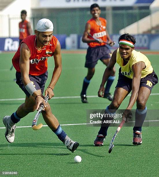 Indian field hockey defender Sandeep Singh tries to take the ball away from Prabodh Tirkey during a team practice session at the National Hockey...