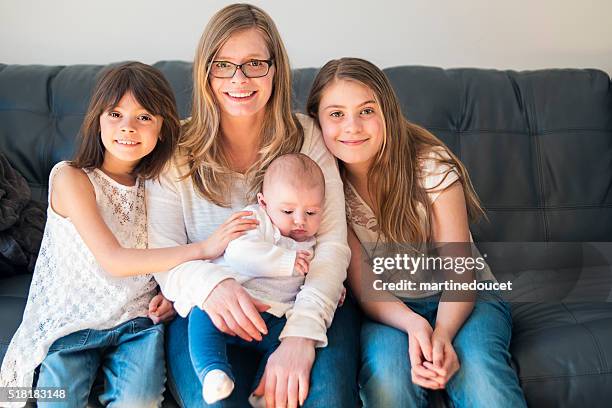 porträt von mutter und töchter, sitzen auf der sofa zu hause fühlen. - drei kinder stock-fotos und bilder