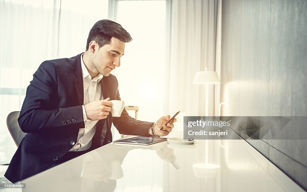 Geschäftsmann mit Digitaltablett und Telefon