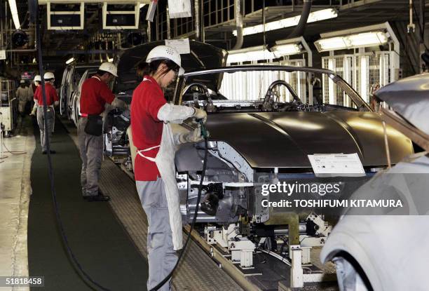 Workers assemble Fairlady Z sports car at Nissan's Tochigi factory in Utsunomiya city, about 100 kilometres north of Tokyo, 03 December 2004....