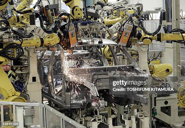 Assembly robots weld the roof panel of a Fuga luxury sedan at Nissan's Tochigi factory in Utsunomiya city, about 100 kilometres north of Tokyo, 03...