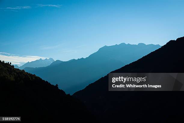 bhutan, trongsa. layers of silhouetted mountains in himalayan foothills. - falda negra imagens e fotografias de stock