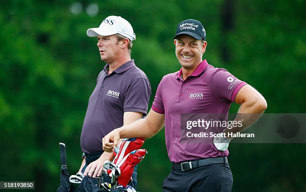 Henrik Stenson of Sweden waits alongside his caddie Gareth Lord during the pro-am prior to the start of the Shell Houston Open at the Golf Club of...