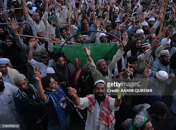 Pakistani supporters of convicted murderer Mumtaz Qadri celebrate after their leaders announced the end of a protest held in front of the parliament...