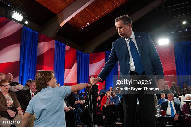 Presidential Candidate John Kasich fist bumps a young fan during a town hall meeting at St. Helen's Roman Catholic Church on March 30, 2016 in the...