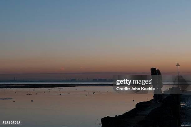 Silhouette of a couple looking out over the Thames Estuary at sunset on January 19, 2016 in Southend on Sea, England.