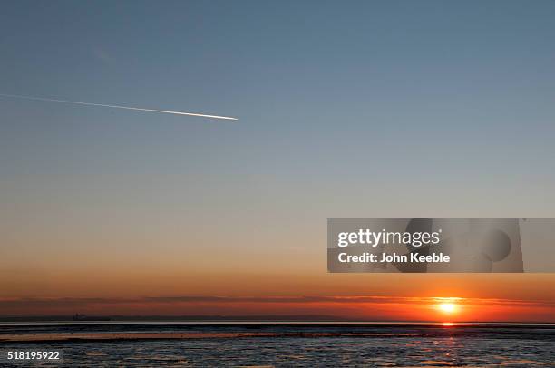 General view of a vapour trail from an aircraft as the sunsets over the Thames Estuary on January January 19, 2016 in Southend on Sea, England.