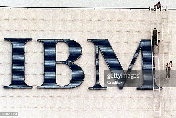 This 02 Septmber shows three Chinese workers maintaining a giant neon-lit IBM billboard in Beijing. International Business Machines Corp has put its...