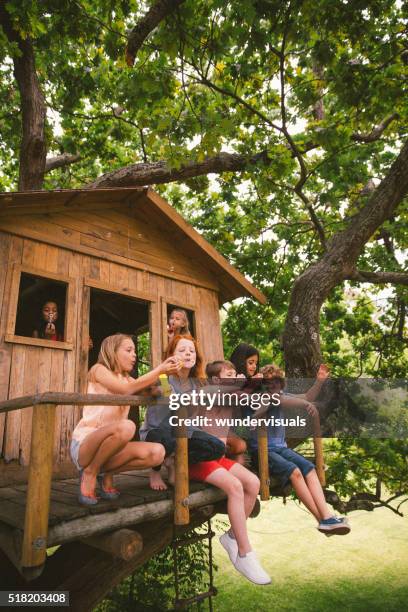 children blowing bubbles on the porch of a wooden treehouse - kids fort stock pictures, royalty-free photos & images