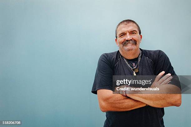 portrait de souriant homme senior avec bras croisés - biker photos et images de collection