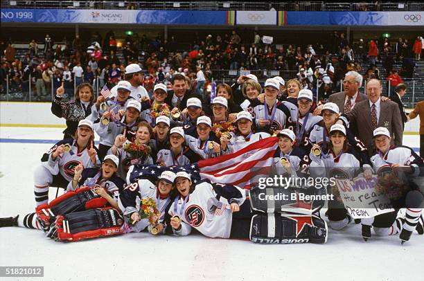Members of United States women's hockey team and coaching staff pose for a team portrait on the ice following the medal ceremony where they were...
