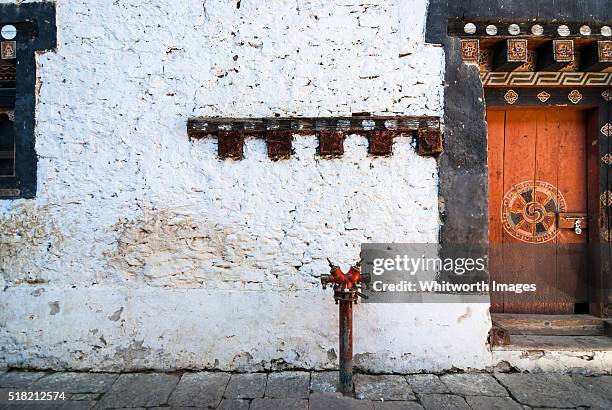 bhutan, trongsa. contrast of ancient architecture and modern fire hydrant in trongsa dzong. - trongsa district fotografías e imágenes de stock