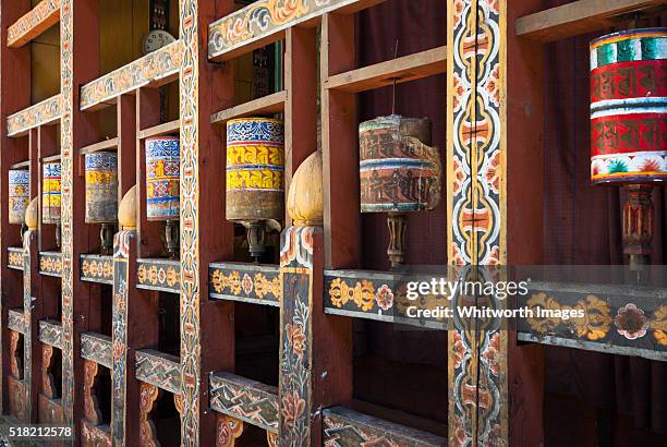 bhutan, trongsa. ancient buddhist prayer wheels in ornate wooden frame. - trongsa district fotografías e imágenes de stock