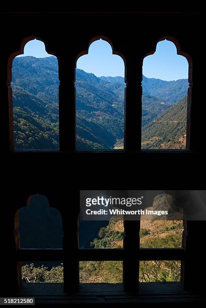 bhutan, trongsa. view to mangde chhu valley through carved window frame. - trongsa district fotografías e imágenes de stock