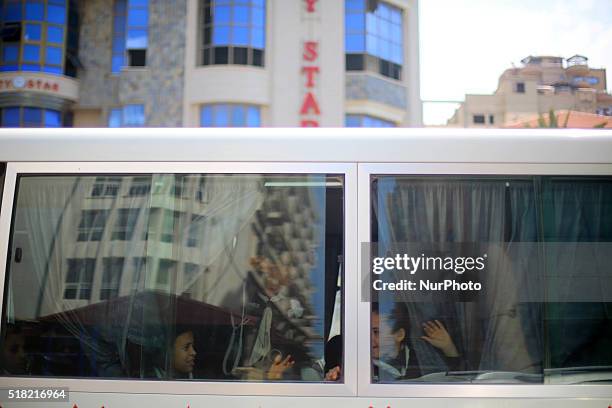 Palestinian children look behind large banners made by Palestinian artists marking the 40th Land Day anniversary, in Gaza City, Wednesday, March 30,...