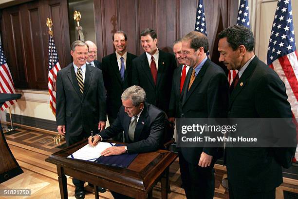 In this handout image provided by the White House, President George W. Bush signs S. 150, The Internet Tax Nondiscrimination Act, with Congressman...