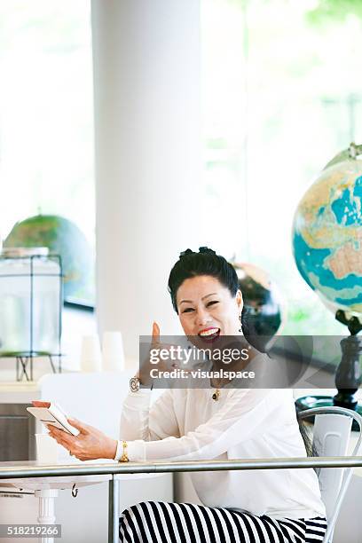 asian woman ready to call up her social network friends - world social media day stock pictures, royalty-free photos & images