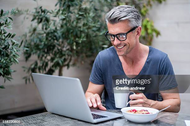 uomo che lavora su un computer portatile - capelli grigi foto e immagini stock