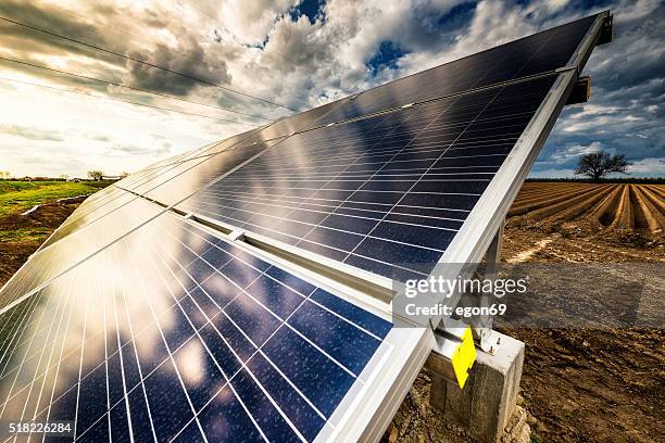 solarenergie panels - gepflügtes feld stock-fotos und bilder