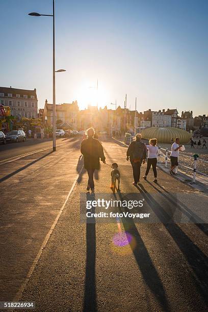 summer sunset holidays seaside tourists walking along promenade weymouth dorset - weymouth esplanade stock pictures, royalty-free photos & images