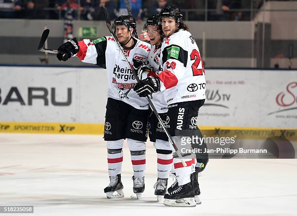 Andreas Falk, Marcel Ohmann and Ryan Jones of Koelner Haie celebrate after scoring the 0:1 during the game between the EHC Red Bull Muenchen and...