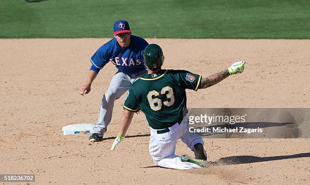 Doug Bernier of the Texas Rangers tags Bruce Maxwell of the Oakland Athletics out at second during a spring training game at Hohokam Stadium on March...